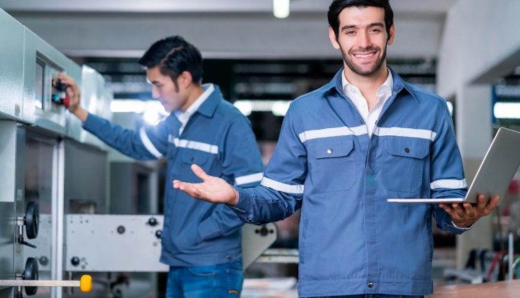 Homem sorrindo enquanto trabalha com equipamentos industriais, representando uma carreira que paga bem com curso técnico.