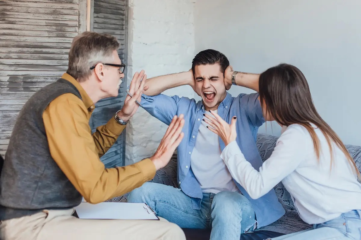  Jovem cobrindo os ouvidos enquanto pais discutem, representando tensão em famílias tóxicas