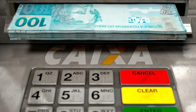 Notas de R$ 100 sendo retiradas de um caixa eletrônico da CAIXA.