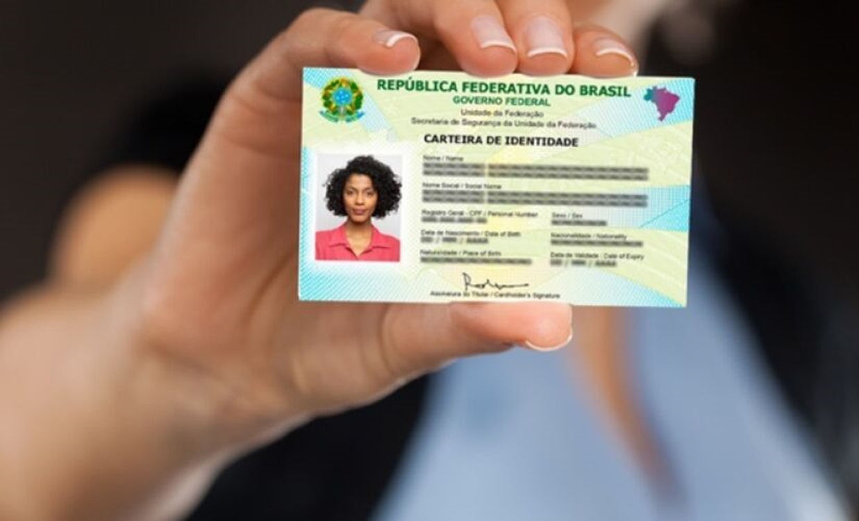 Pessoa segurando o novo RG brasileiro com foto e dados pessoais.