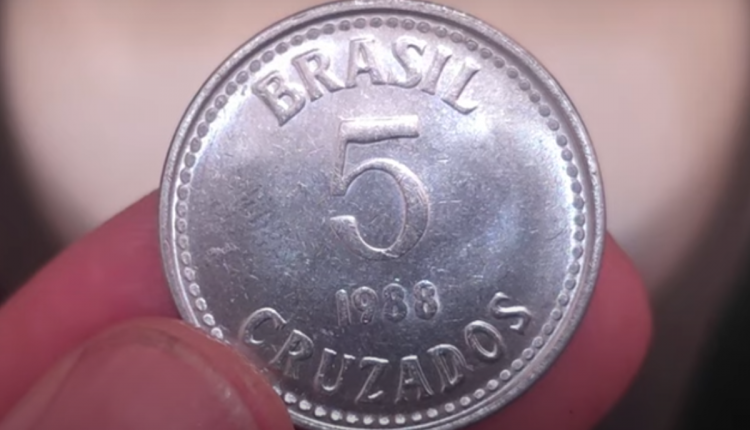 Moeda antiga de 5 cruzados de 1988 com detalhes visíveis da inscrição Brasil e valor