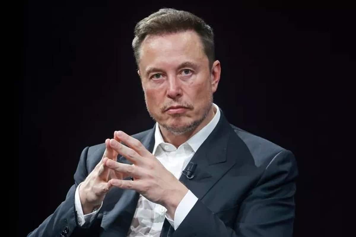 Elon Musk em um retrato sério, com mãos juntas na frente do corpo