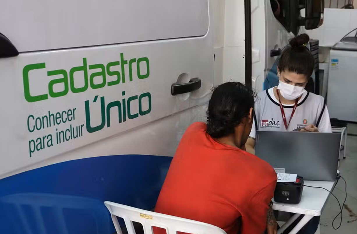 Atendimento no mutirão de atualização do Cadastro Único em Dourados, MS, com auxílio de um servidor público.