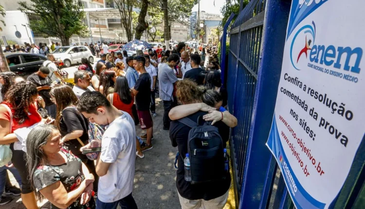 Estudantes aguardando para realizar o Exame Nacional do Ensino Médio (Enem) em frente ao local de prova.