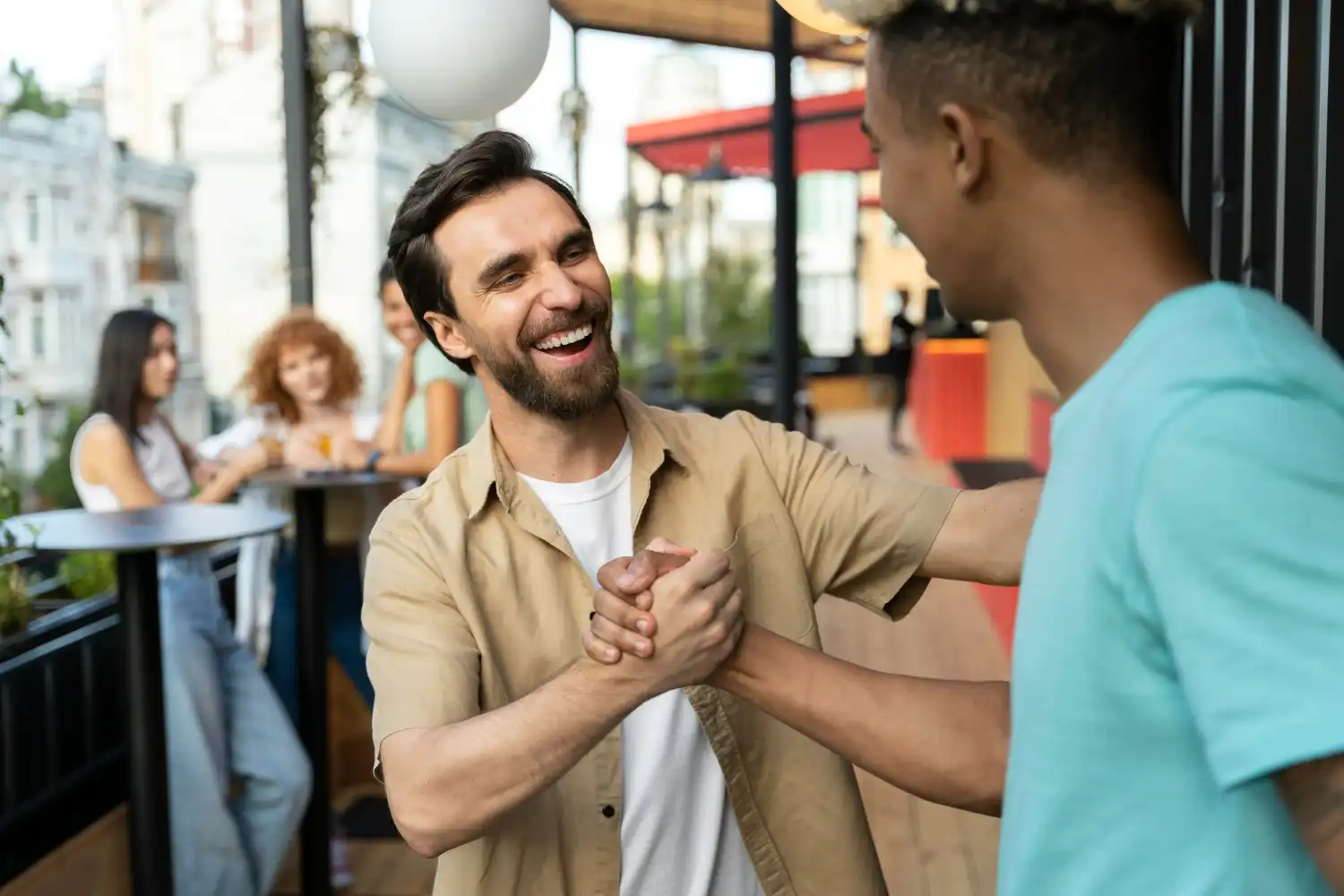 Dois homens sorrindo e se cumprimentando com um aperto de mão, simbolizando a construção de pontes e boas relações.