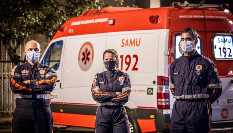 Profissionais do SAMU em frente a ambulância de suporte avançado.