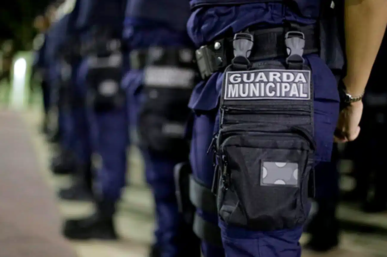 Guarda Municipal em formação, com colete de identificação e preparado para garantir a segurança pública.