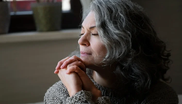 Mulher de cabelos grisalhos com expressão reflexiva, representando o medo da solidão na velhice.