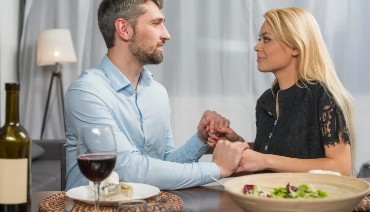 Casal em momento íntimo durante jantar, representando a manipulação emocional em relacionamentos narcisistas.