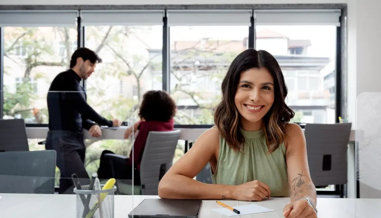 Profissional sorridente em escritório moderno, representando oportunidades de profissões que pagam até R$ 30 mil.