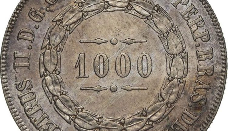 Moeda antiga de 1000 réis com data 1863 e inscrições históricas