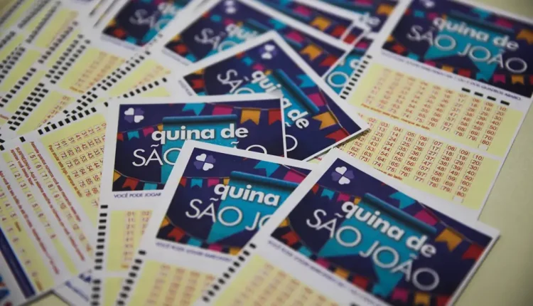 Volantes da Quina de São João espalhados sobre a mesa, prontos para apostas no sorteio de R$ 230 milhões.