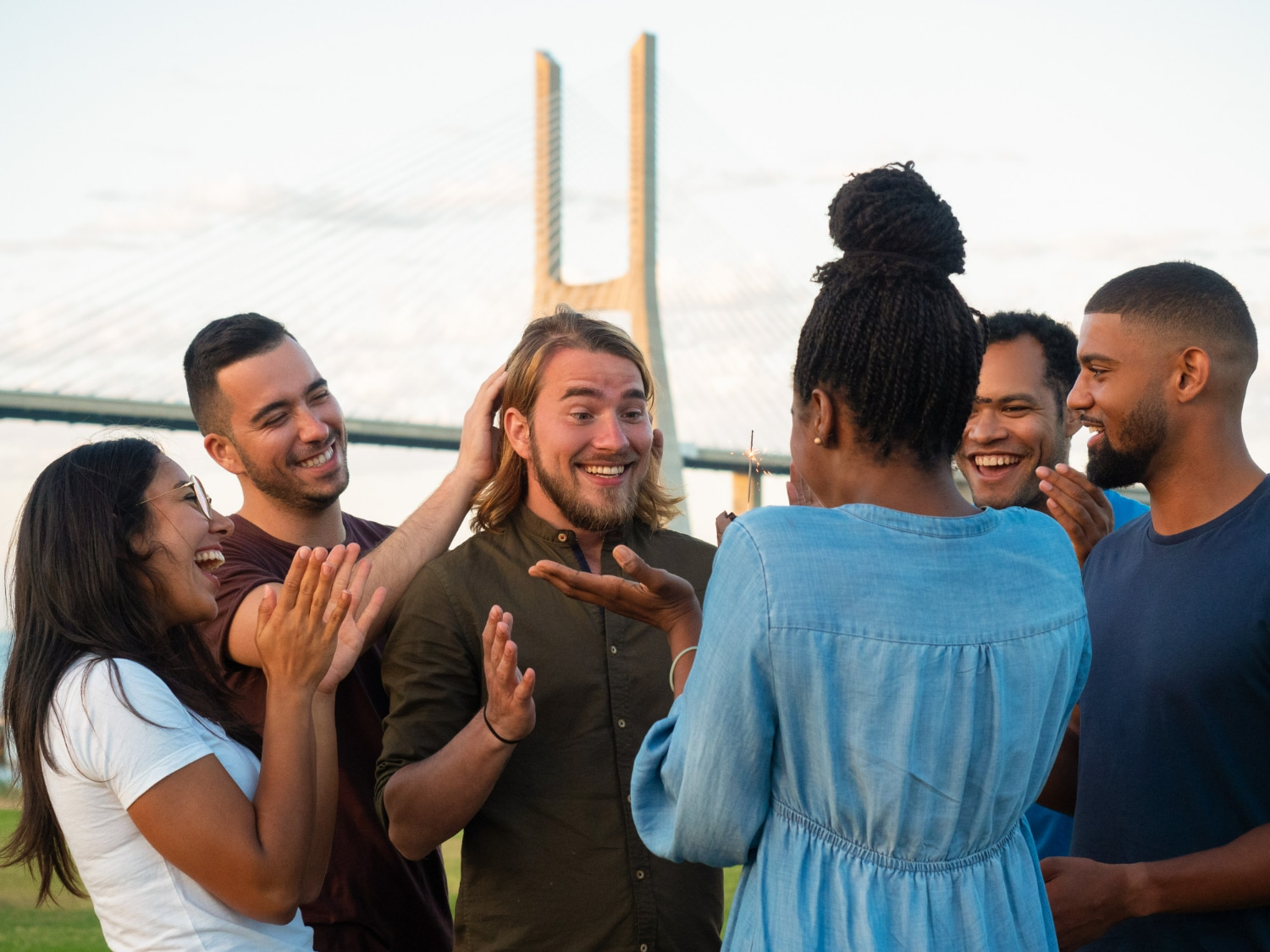 Grupo de amigos se divertindo juntos, celebrando e sorrindo ao ar livre.