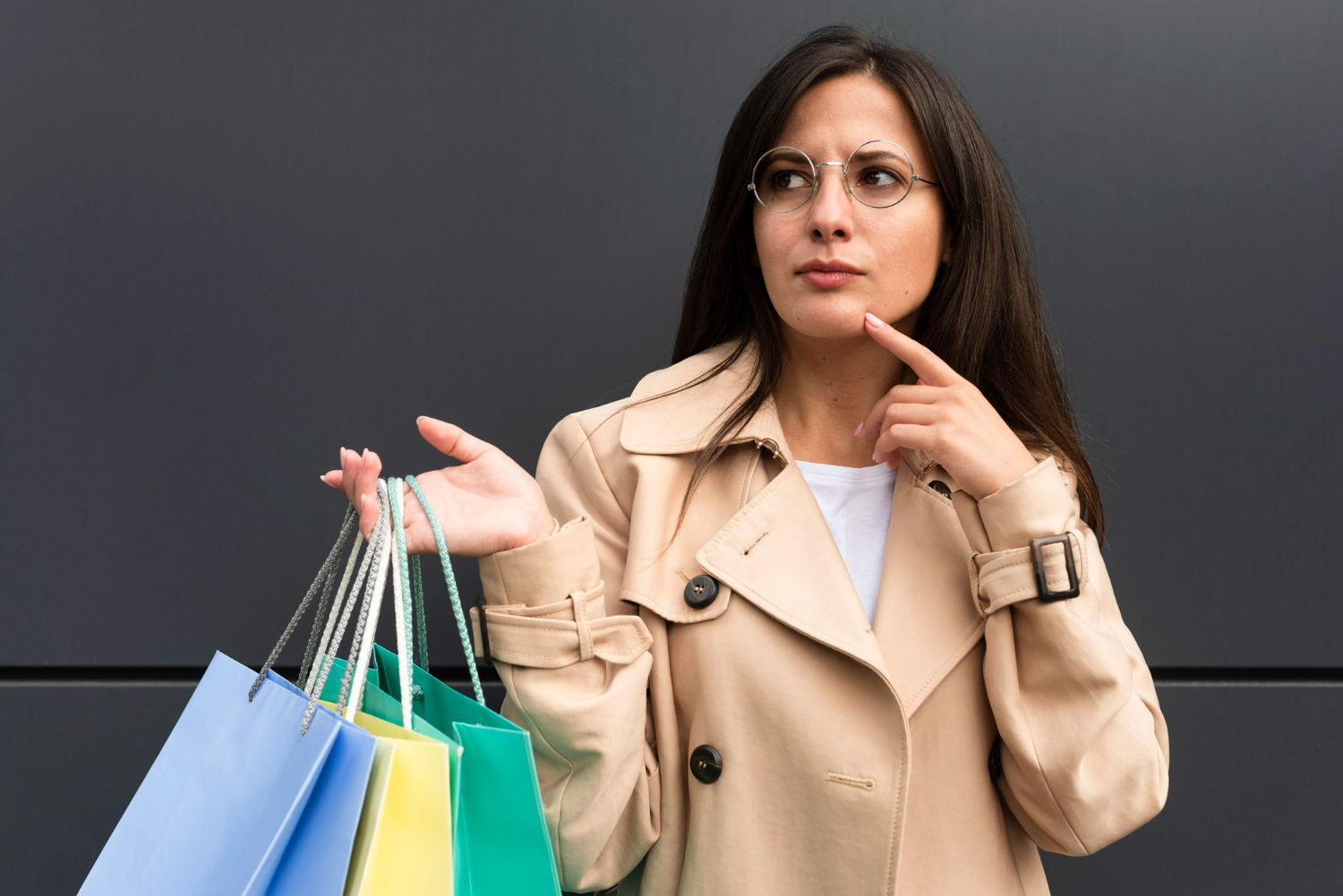 Mulher com sacolas de compras refletindo sobre suas finanças, simbolizando a classe social e o poder de compra de quem ganha R$ 5 mil.
