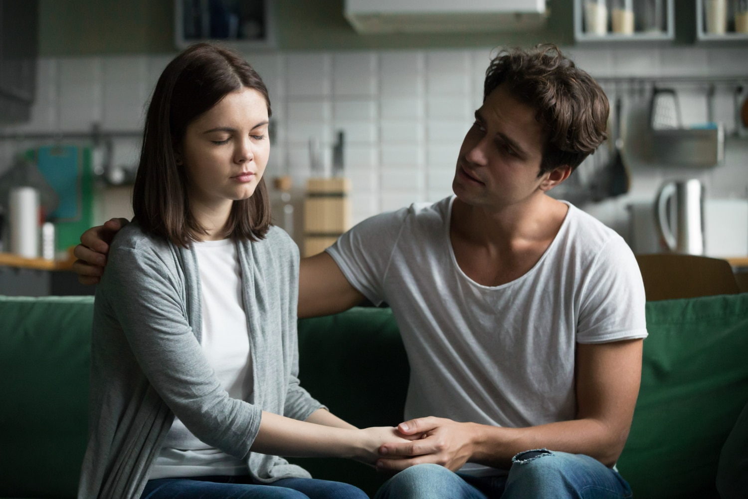 Casal em uma conversa emocional, com o homem oferecendo apoio enquanto a mulher parece preocupada, refletindo a falta de envolvimento em uma situação.