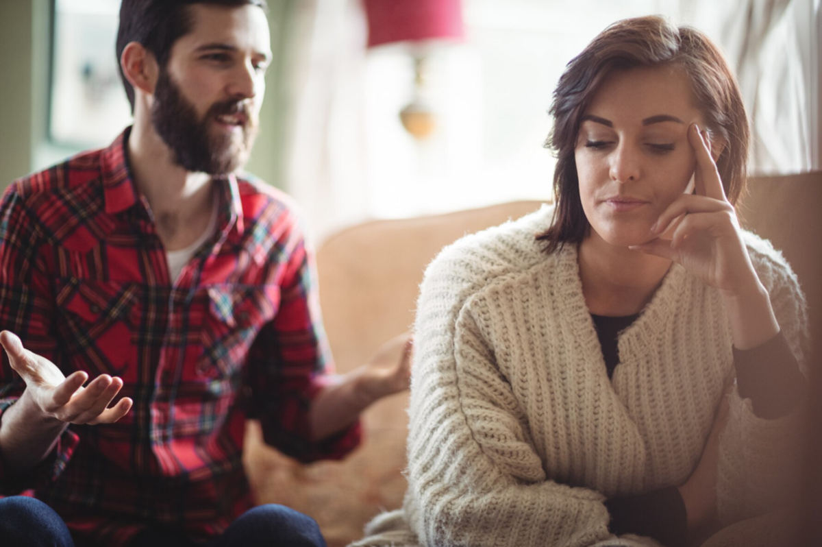 Imagem de um casal em discussão, com o homem falando e a mulher claramente desconfortável.