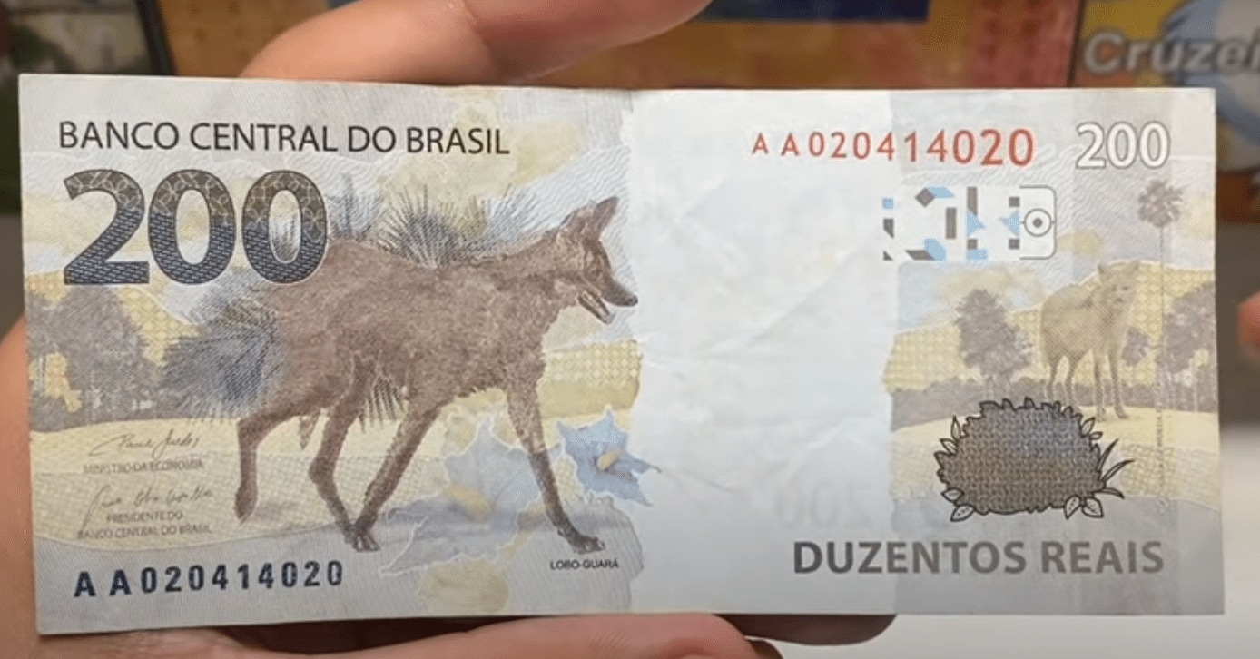 Cédula de 200 reais com destaque para o número de série e imagem do lobo-guará