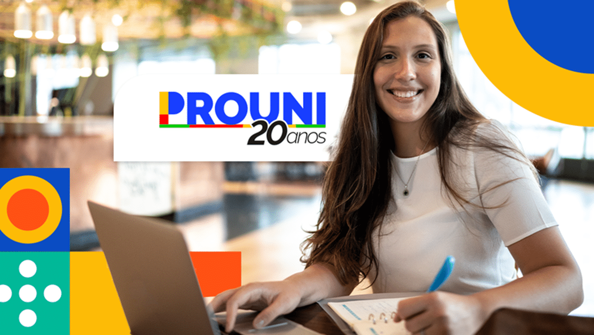 Imagem de uma jovem sorrindo enquanto trabalha no computador com o logo do Prouni 20 anos ao fundo.