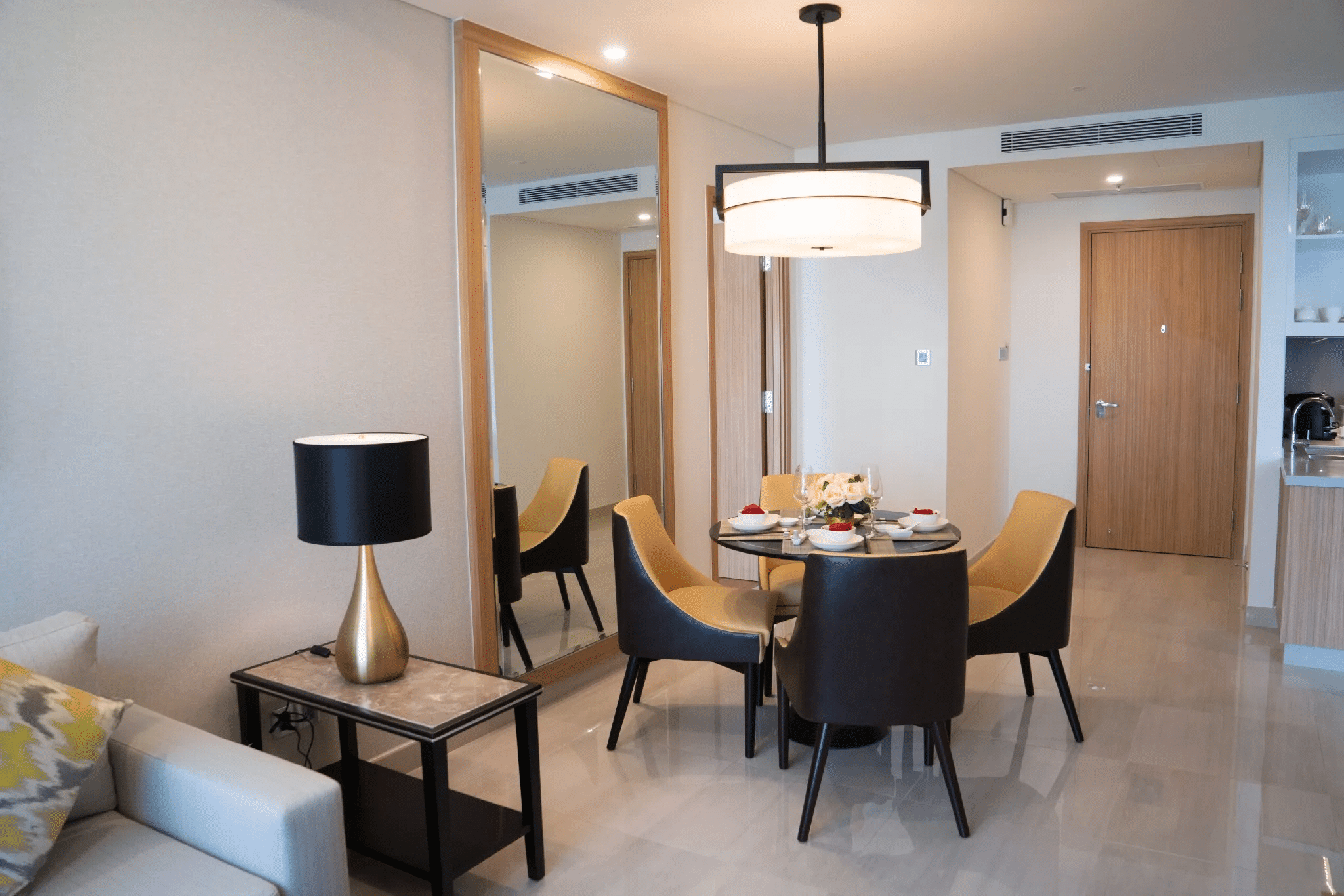 Área de jantar moderna e compacta com mesa posta em ambiente mobiliado.