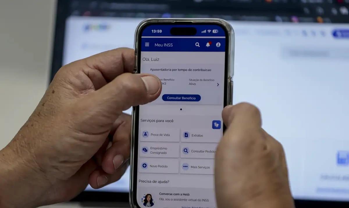 Pessoa acessando o aplicativo Meu INSS no celular para consultar benefício.