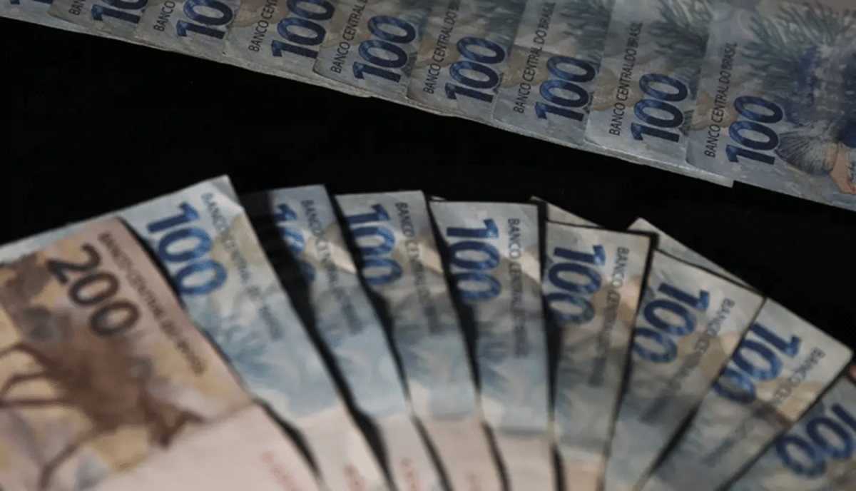 Notas de 100 reais ilustrando o processo de solicitação do saque FGTS online.