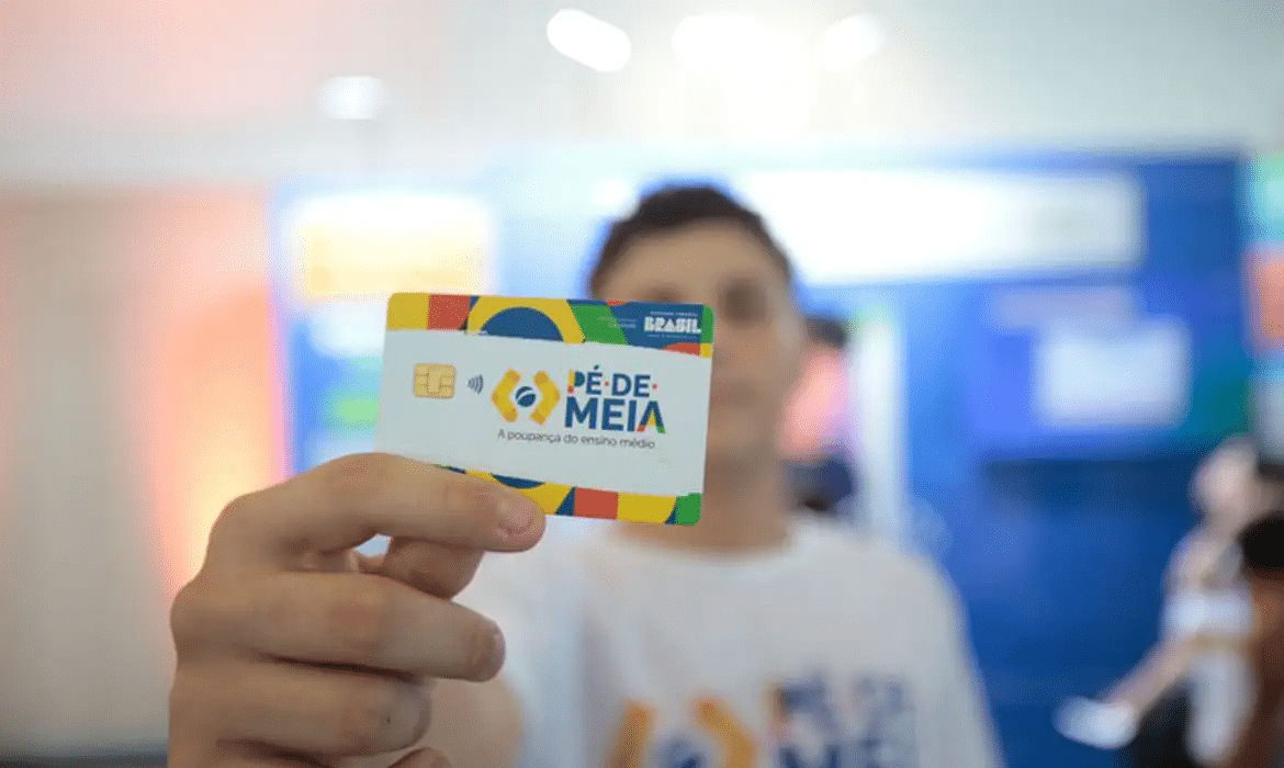 Estudante segura o cartão do programa Pé-de-Meia com destaque para o benefício.