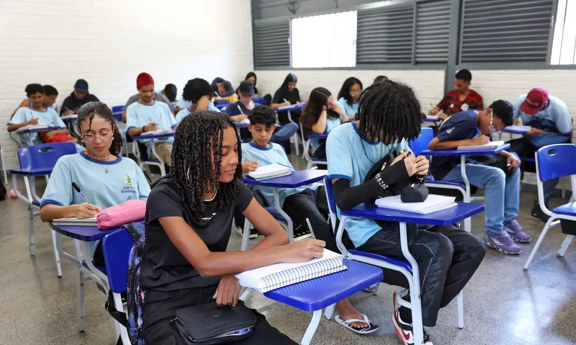 Estudantes do ensino médio escrevendo em sala de aula.
