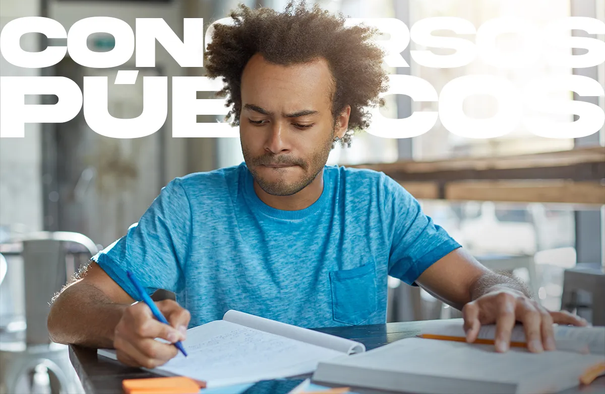 Jovem concentrado estudando sobre uma mesa com materiais de estudo
