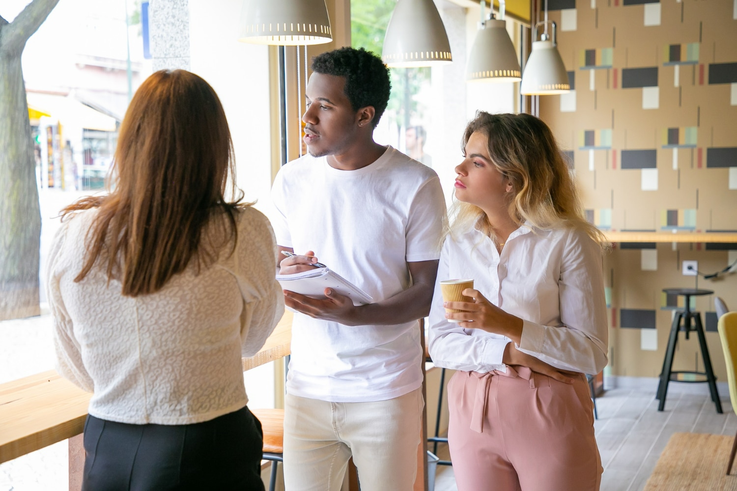 Grupo de pessoas conversando em ambiente de café, representando uma interação social.
