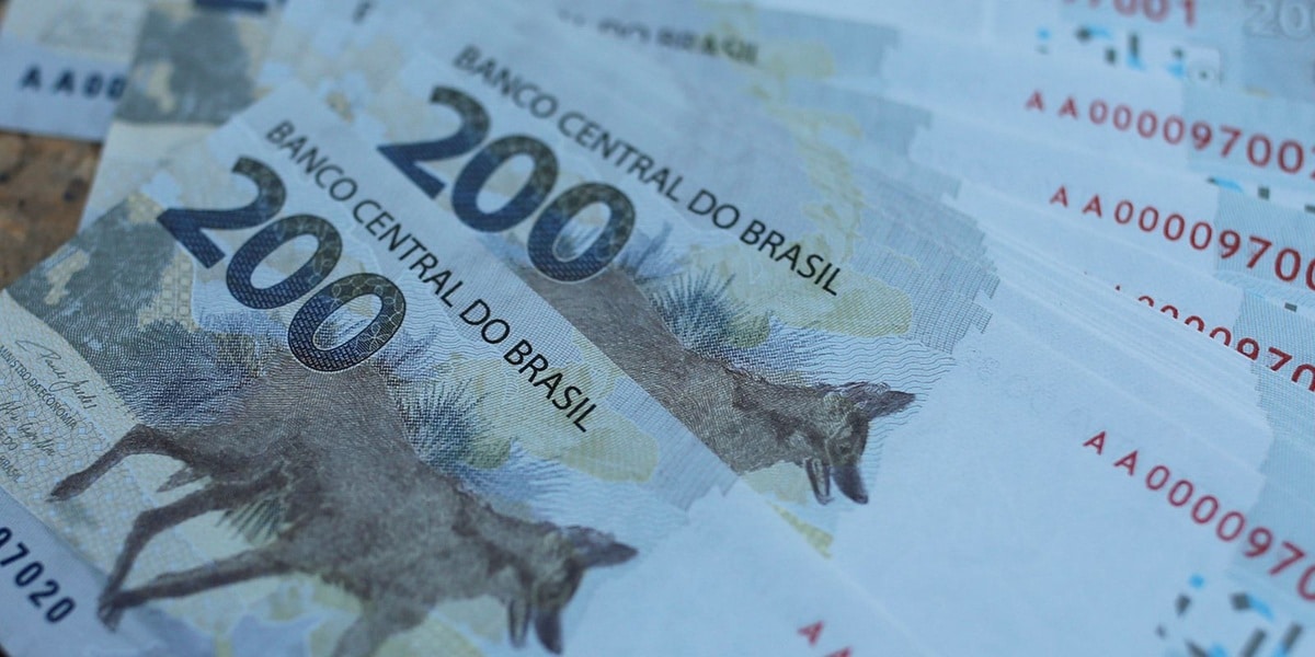 Notas de 200 reais brasileiros sobrepostas mostrando valor máximo do benefício previdenciário