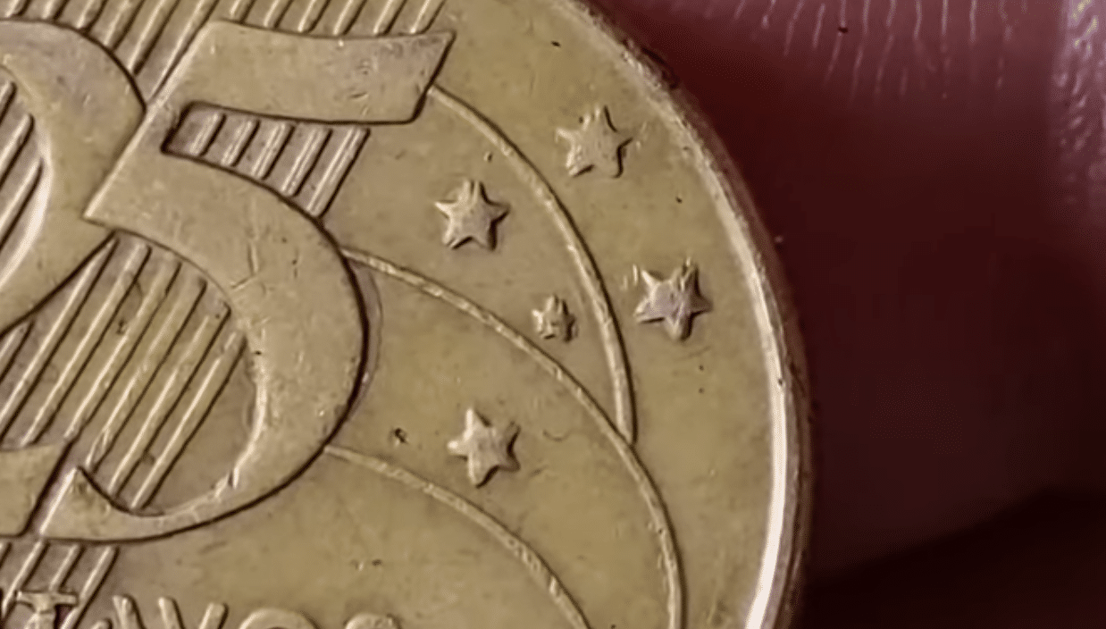 Close-up da moeda de 25 centavos de 2002 com defeito raro de estrelas duplicadas no reverso