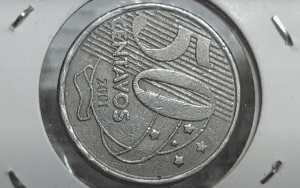 A imagem do anverso de uma moeda de 50 centavos, com o ano 2001 visível, com um erro de cunhagem que a torna valiosa.