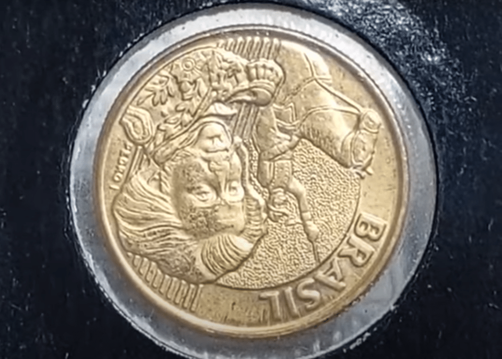 Close-up da moeda de 10 centavos com o reverso invertido, detalhando o erro de cunhagem.