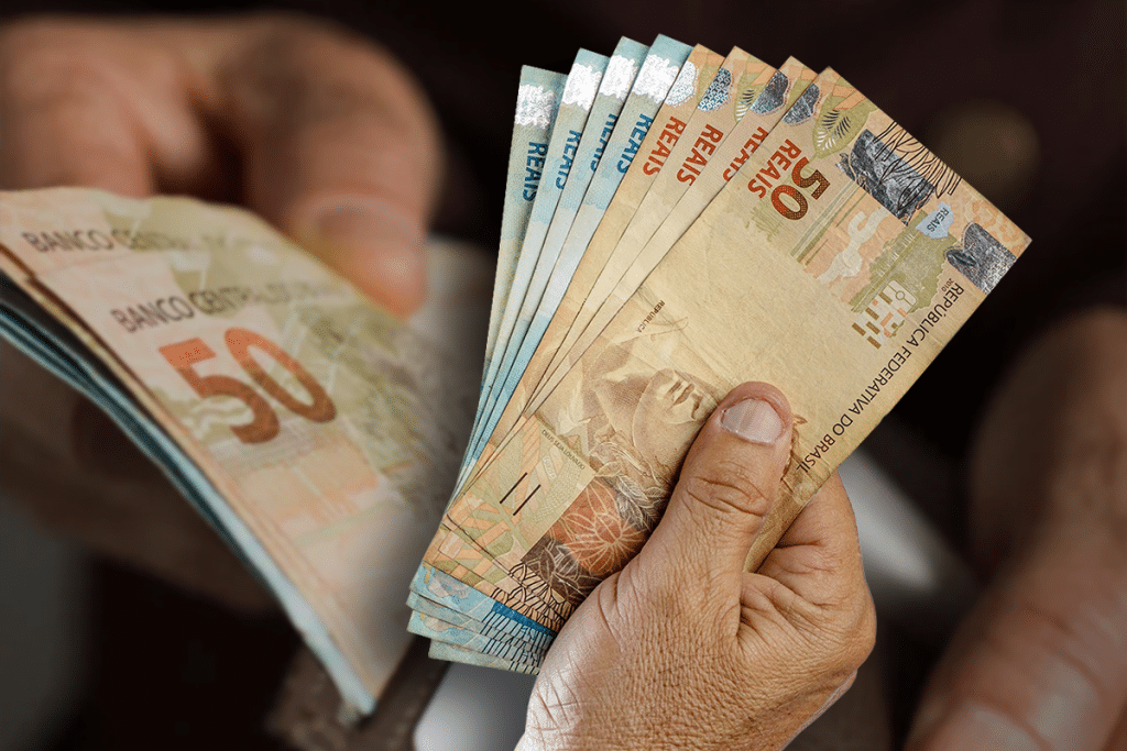 Notas de 50 reais sendo contadas com ênfase no valor e na data de pagamento em 25/08.