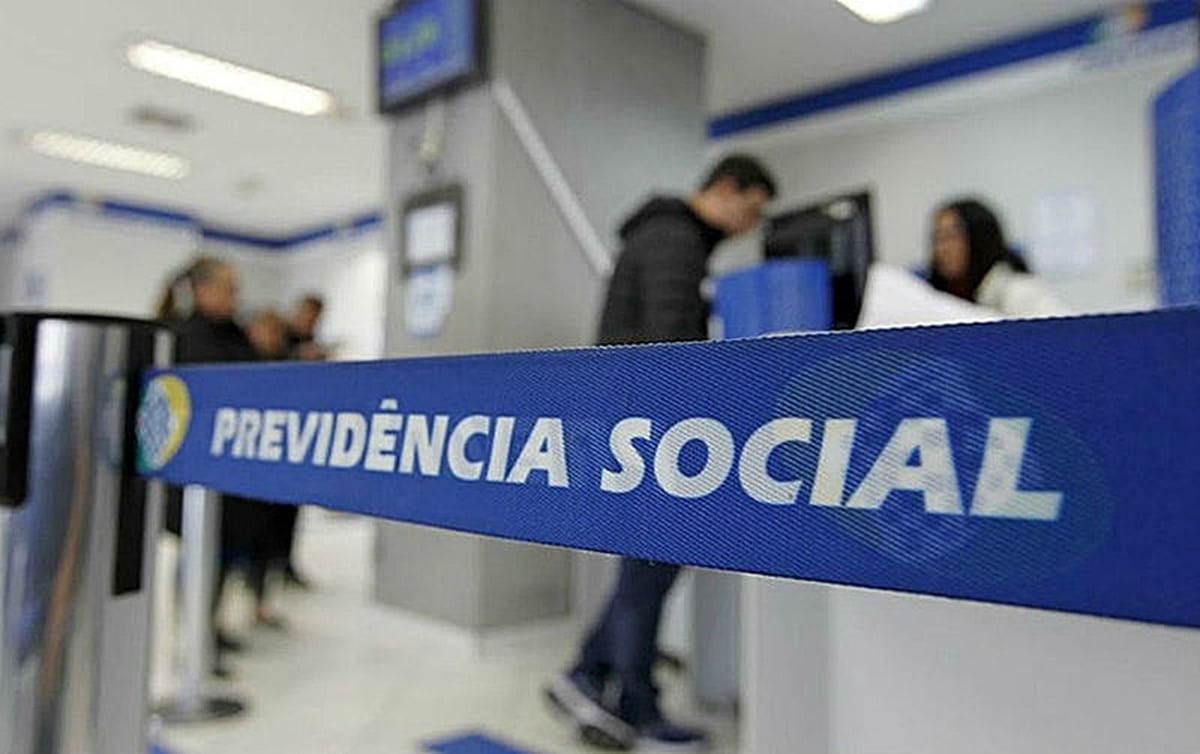 Fila de atendimento da Previdência Social, com pessoas aguardando para acessar serviços relacionados ao INSS.