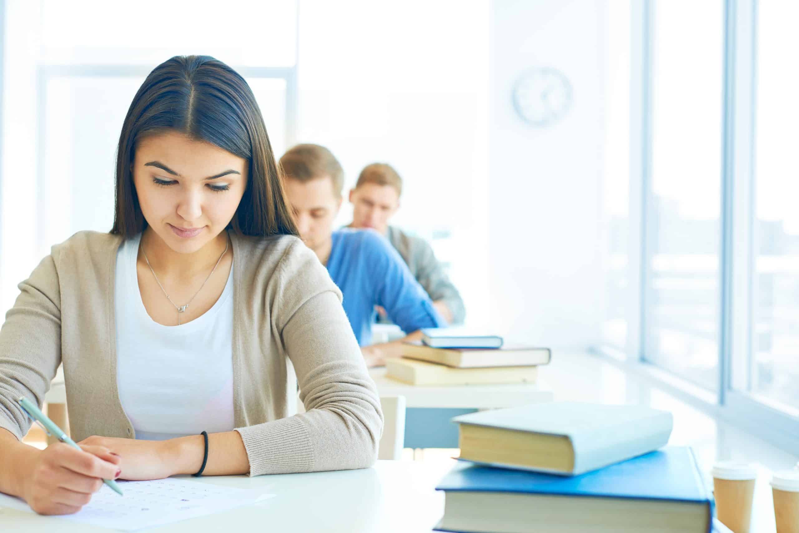 Estudante se concentrando em uma prova, simbolizando a preparação para concursos públicos.