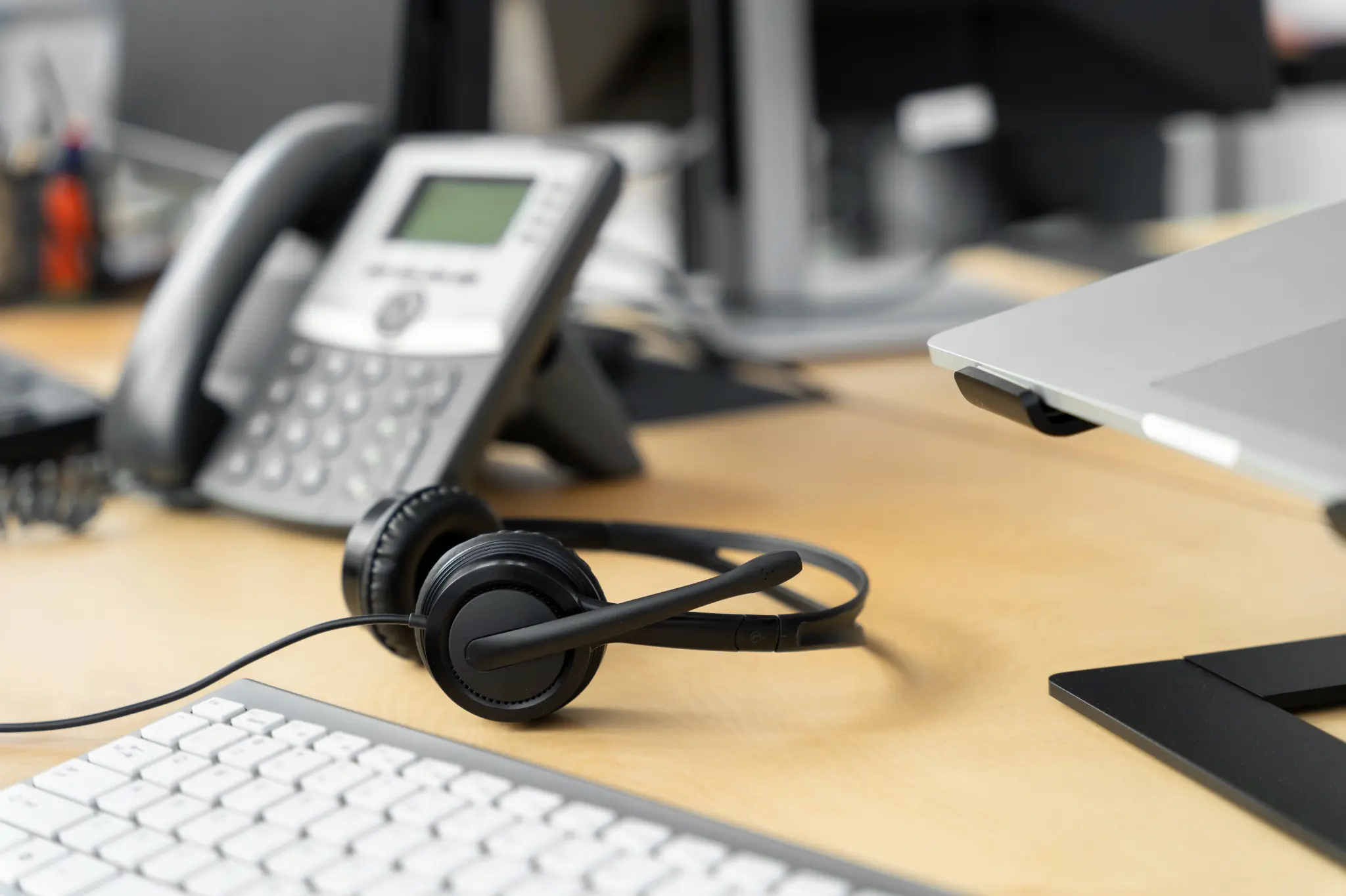 Fones de ouvido em uma mesa de escritório, simbolizando o atendimento ao cliente e as mudanças nas telecomunicações após a revogação do prefixo 0303 pela Anatel.