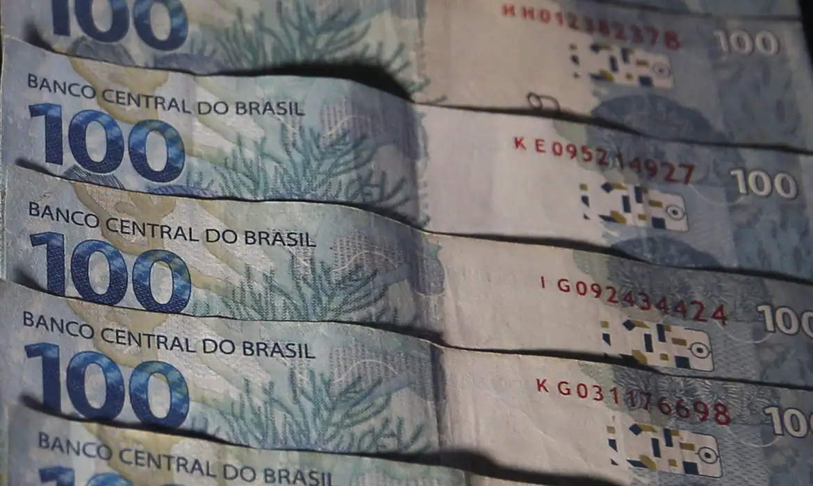 Cédulas de R$ 100 representando os pagamentos do Pé-de-Meia e do ressarcimento PIS/Pasep liberados pela Caixa