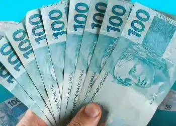 Notas de R$ 100 em dinheiro representando o Saque Calamidade do FGTS de até R$ 6.220 para trabalhadores elegíveis