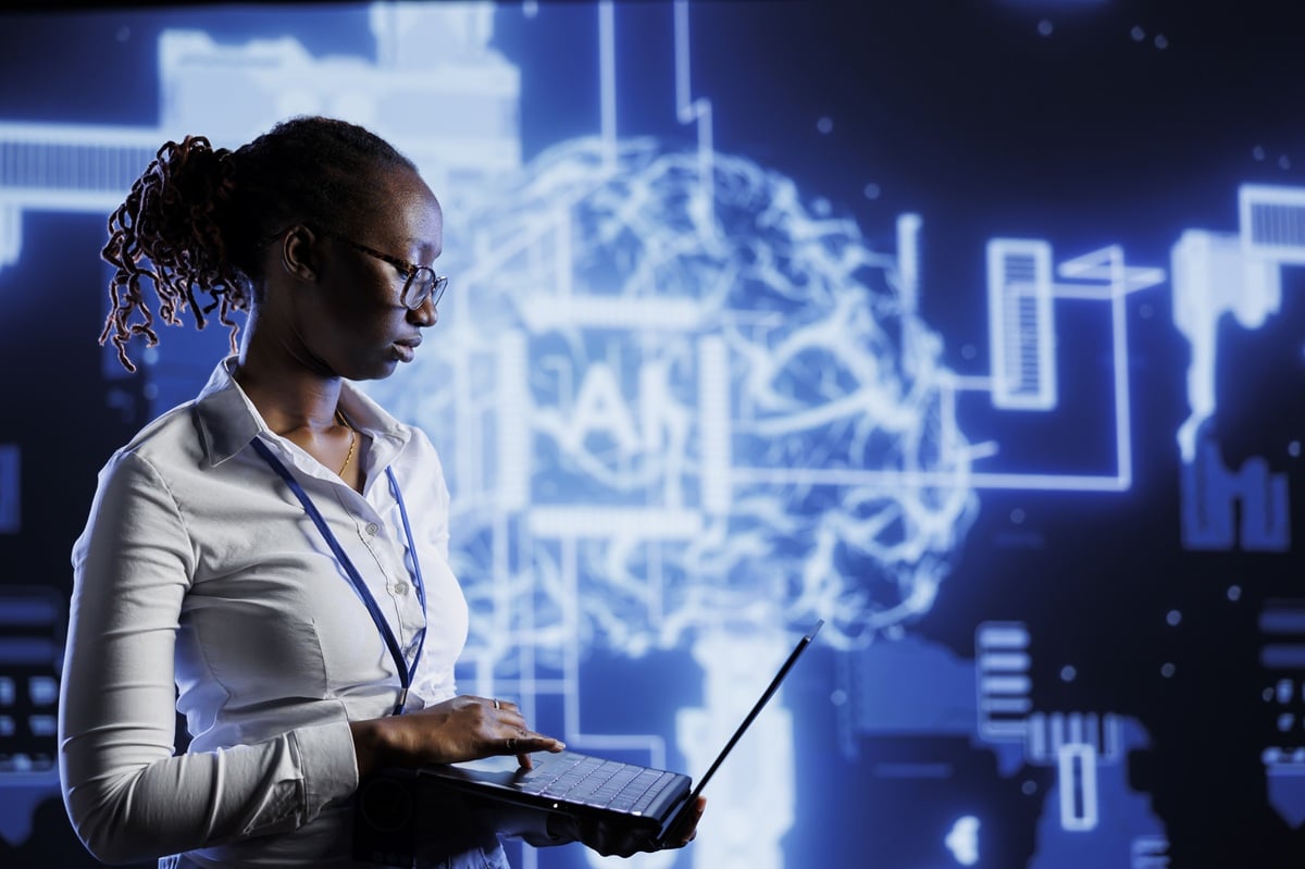 Mulher analisando dados com um laptop, representando o avanço da IA nas profissões de TI