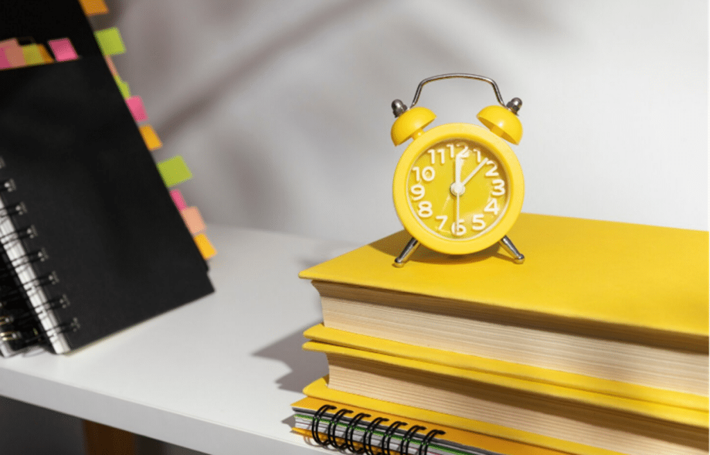 Relógio de mesa amarelo e organização para estudos.