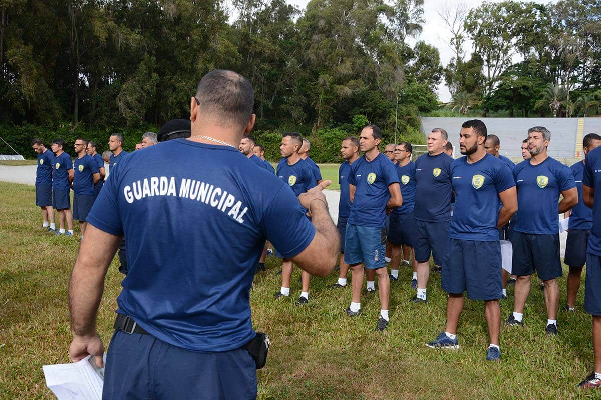 Guardas municipais participando de treinamento físico em área aberta.