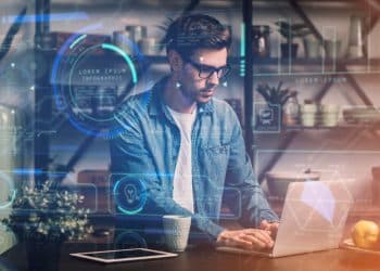 Homem trabalhando em laptop com sobreposição de elementos digitais holográficos representando ferramentas de inteligência artificial