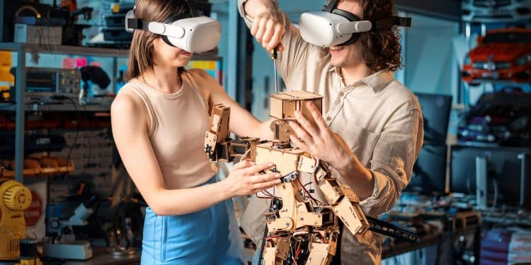 Dois jovens usando óculos de realidade virtual montando um robô de madeira com componentes eletrônicos em oficina tecnológica.