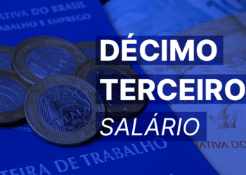 Moedas de um real sobre carteira de trabalho com texto décimo terceiro salário