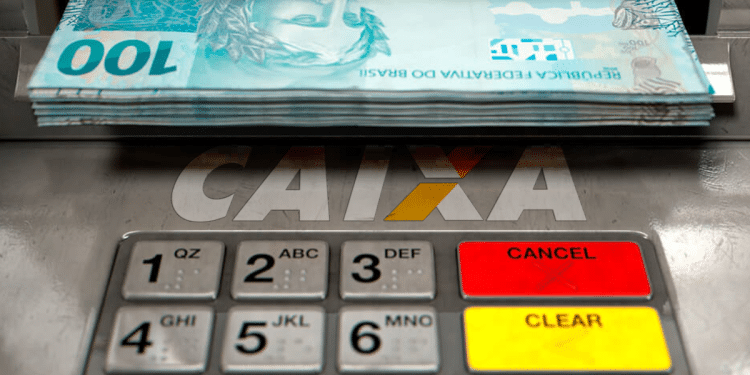 Caixa eletrônico da Caixa Econômica Federal com notas de cem reais disponíveis para saque