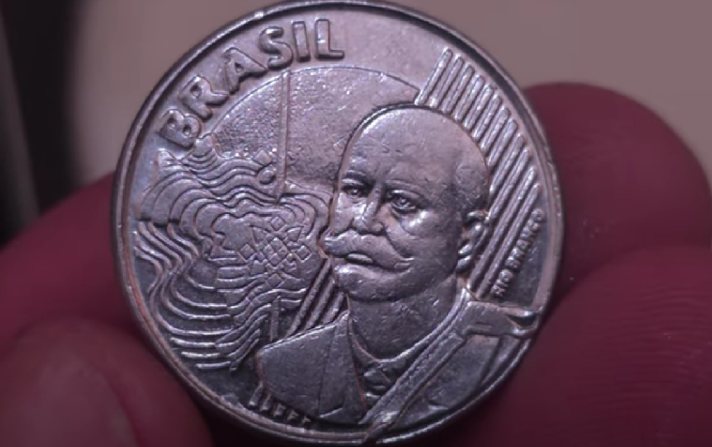 Moeda brasileira de 50 centavos com erro de cunhagem, mostrando o rosto de Barão do Rio Branco e a palavra BRASIL na parte superior.