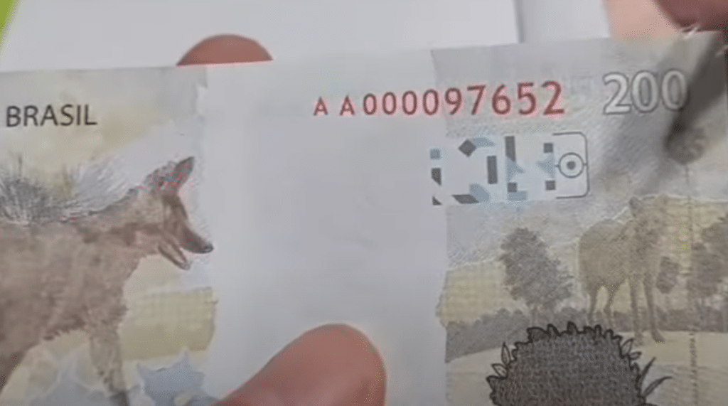 Detalhe da cédula de 200 reais com a série "AA" e a numeração visíveis, indicando uma possível raridade e valor para colecionadores.