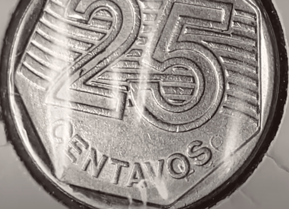 Close de uma moeda rara de 25 centavos de 1994, com destaque para o erro de "data marcada".