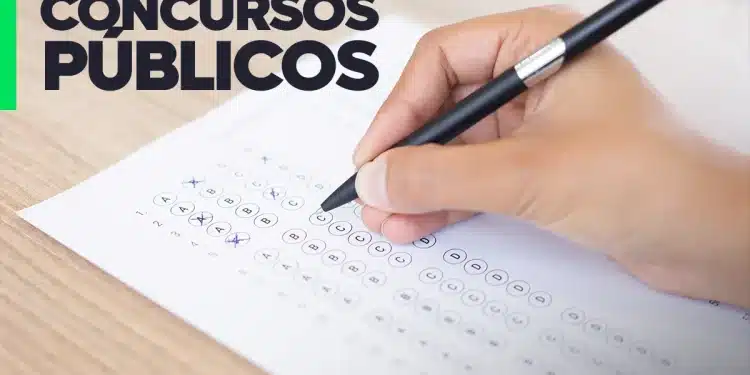 Pessoa preenchendo gabarito de prova de concurso público com caneta. O papel tem a inscrição 'CONCURSOS PÚBLICOS'.
